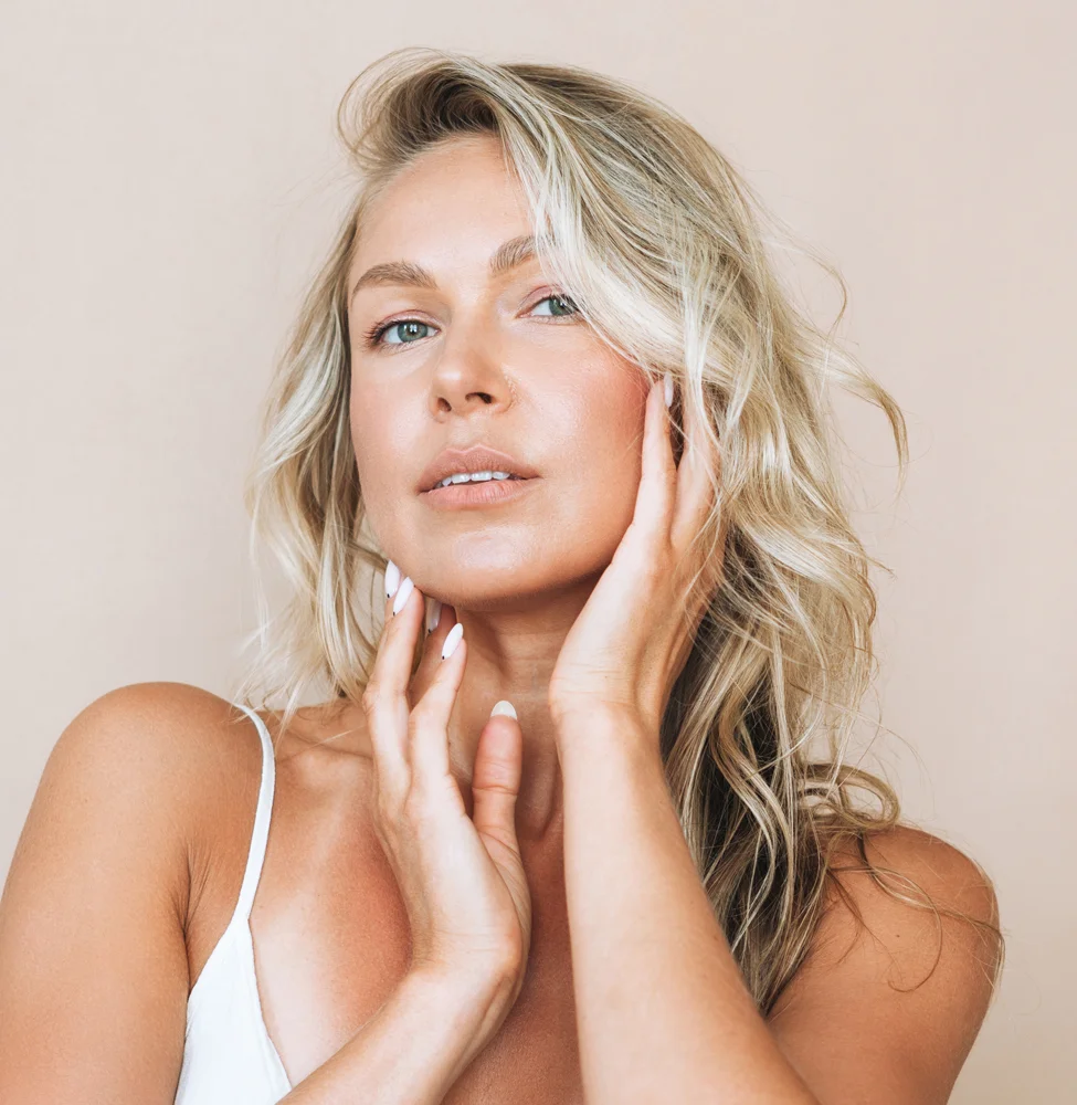 Blonde haired woman with her hands are gently resting on her faceo | IPL Photo Rejuvenation in Boise
